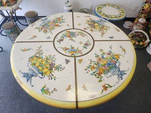 lot 227 image: Truly a masterpiece. This handcrafted tabletop was created in 5 separate pieces and assembled with brass trim at each seam. This hand painted top of flowers, fruits, birds and butterflies is signed by the artist who created it. Includes base - (29 x 54)