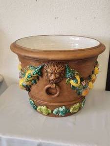 lot 121 image: Large terra cotta colored cache pot ringed with fruit garlands and embellished with lion heads on each side