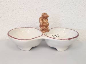 lot 202 image: Whimsical monkey sits guard over this two-compartment dish trimmed in red