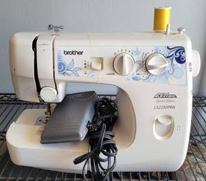 lot 34 image: BROTHER PROJECT RUNWAY LIMITED EDITION SEWING MACHINE WITH COVER AS SHOWN.